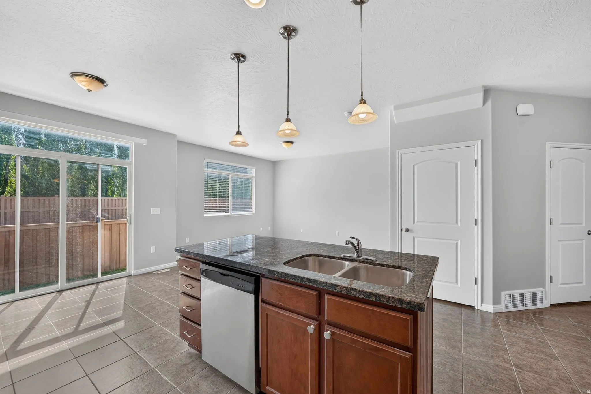 Kitchen island with dark countertop and double basin sink