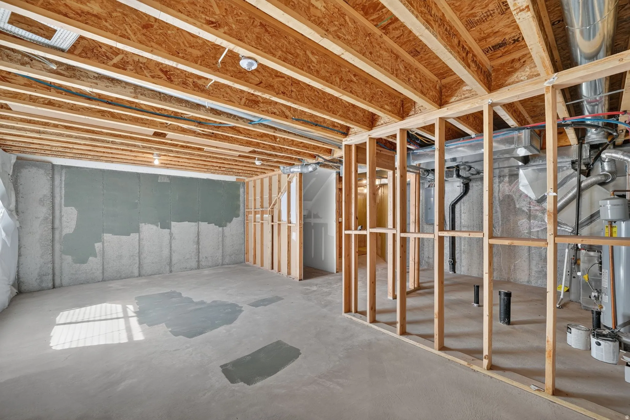 Unfinished basement space featuring exposed wood joists and concrete flooring