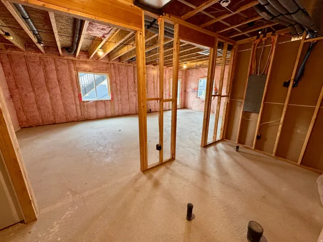 Unfinished basement with exposed ceiling joists, framed interior walls, and concrete flooring