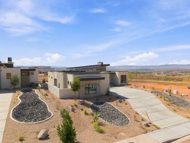 Modern architectural design featuring a flat roofline, stone veneer accents, and large windows