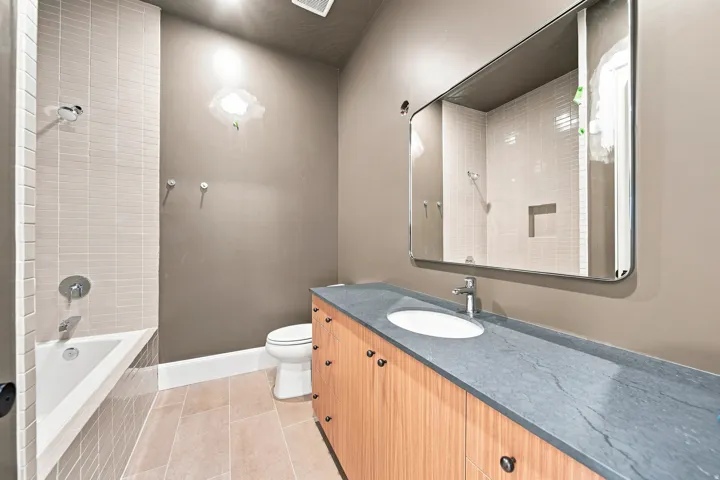 Wood-finish vanity with an integrated sink and a sleek mirror