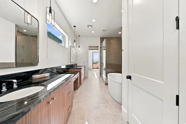 Dual vanity with dark stone countertops and integrated sinks