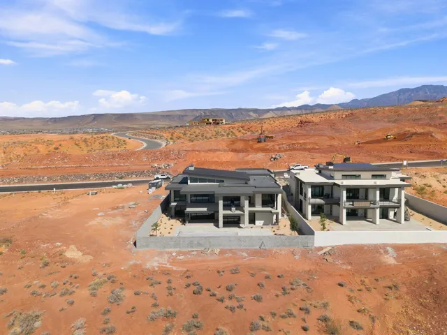 Modern architectural design with multiple balconies, a flat roofline, and desert landscaping
