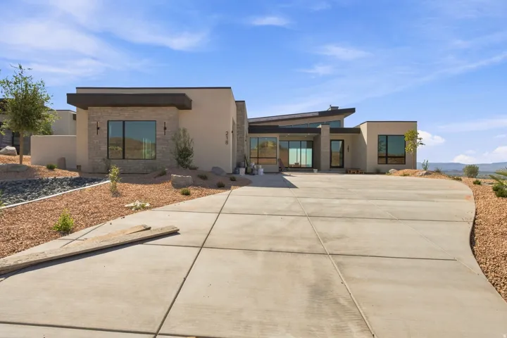 Contemporary stucco exterior with stone accents and a flat roofline