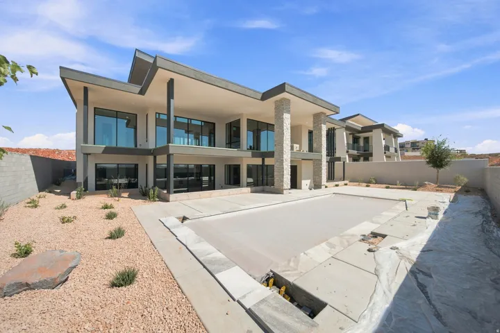 Modern architecture with extensive fenestration, multiple balconies, and a covered patio