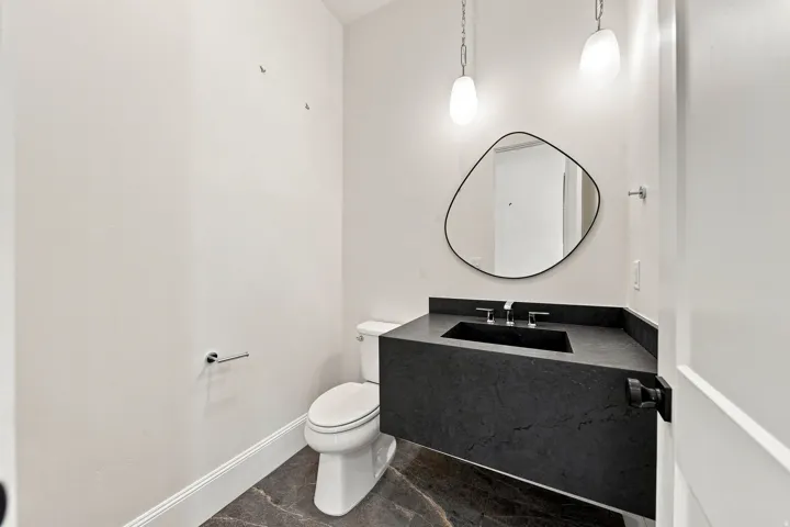 Floating vanity with integrated black sink, black countertop, and contemporary mirror