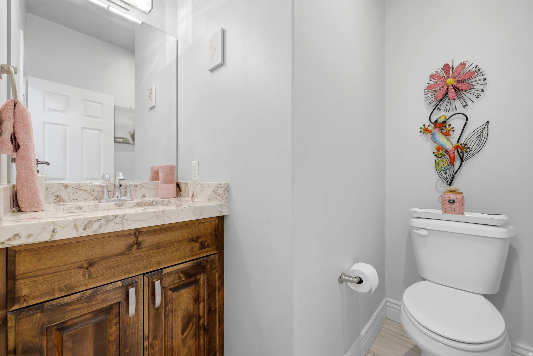 Bathroom vanity featuring a wood-finish cabinet with double doors and silver-tone pulls