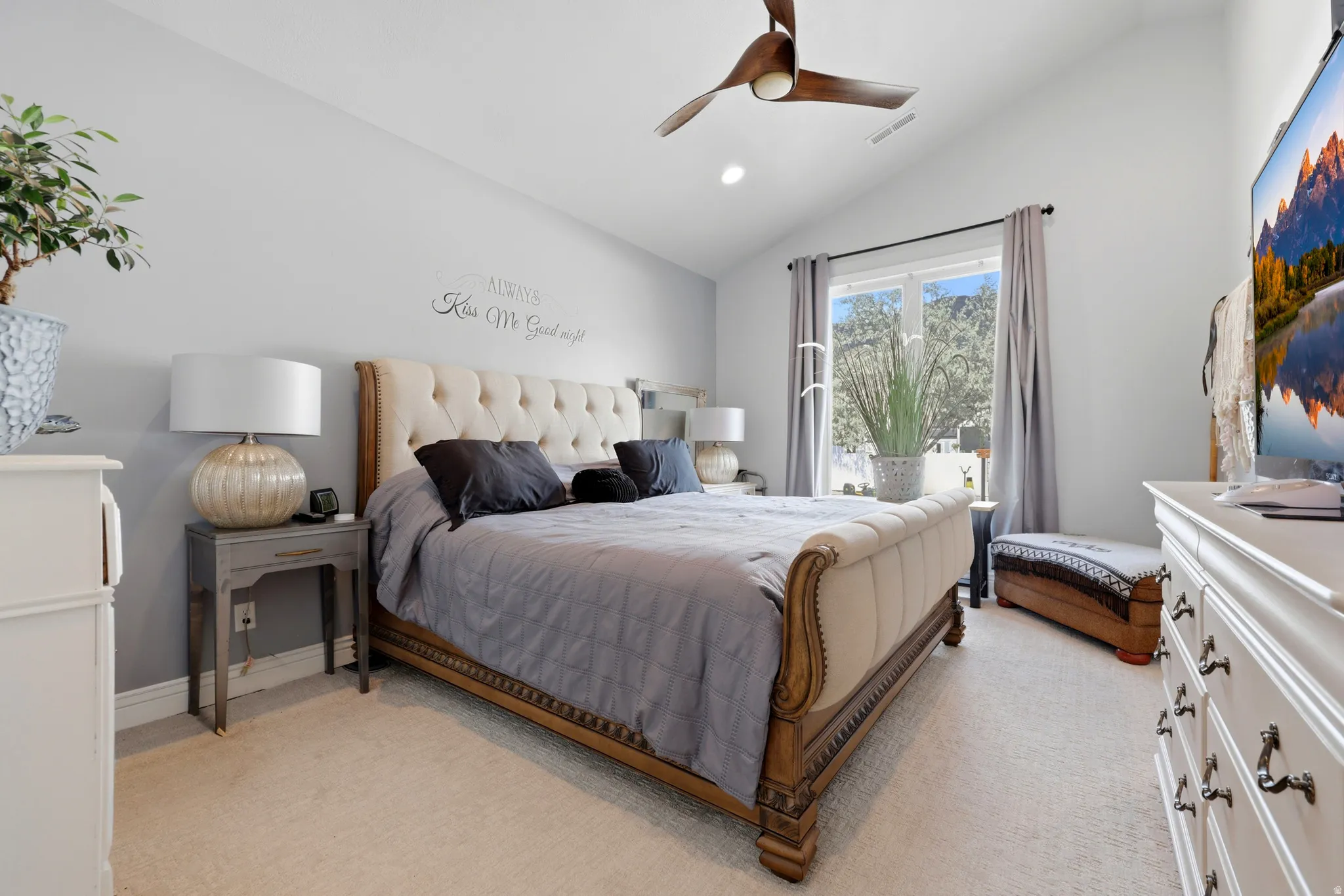 Vaulted ceiling bedroom with light-toned carpeting and recessed lighting