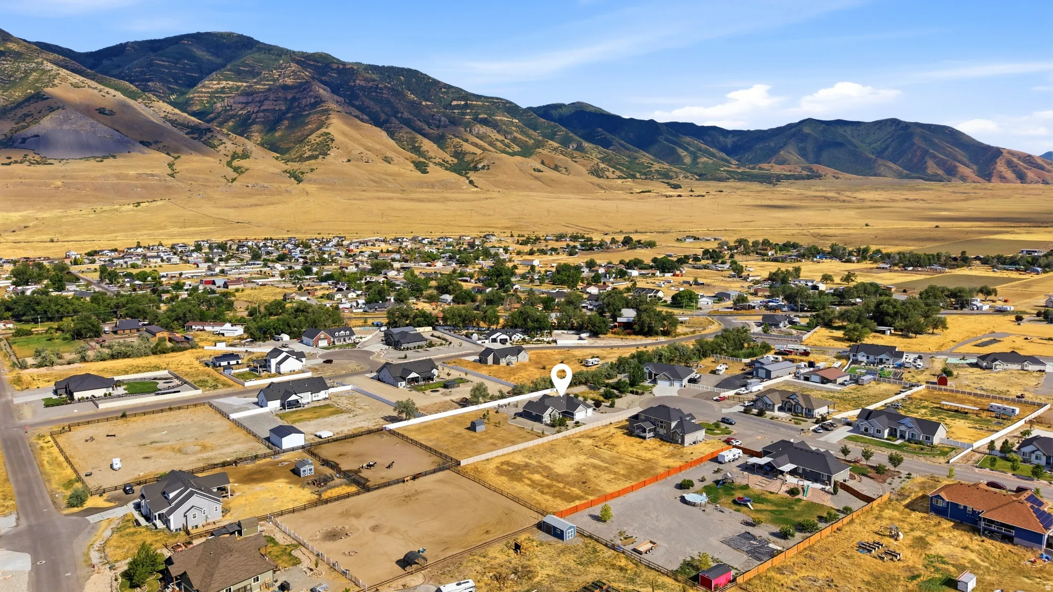 Expansive aerial perspective showcasing a residential area set against a backdrop of rolling mountains