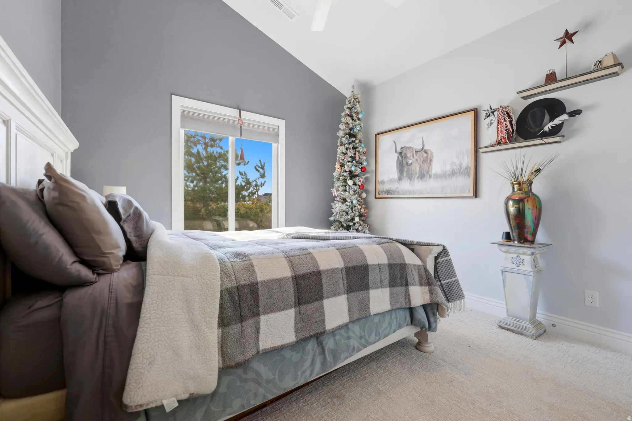 Bedroom featuring a vaulted ceiling with a ceiling fan, a large window, light-toned carpeting, and a white baseboard trim