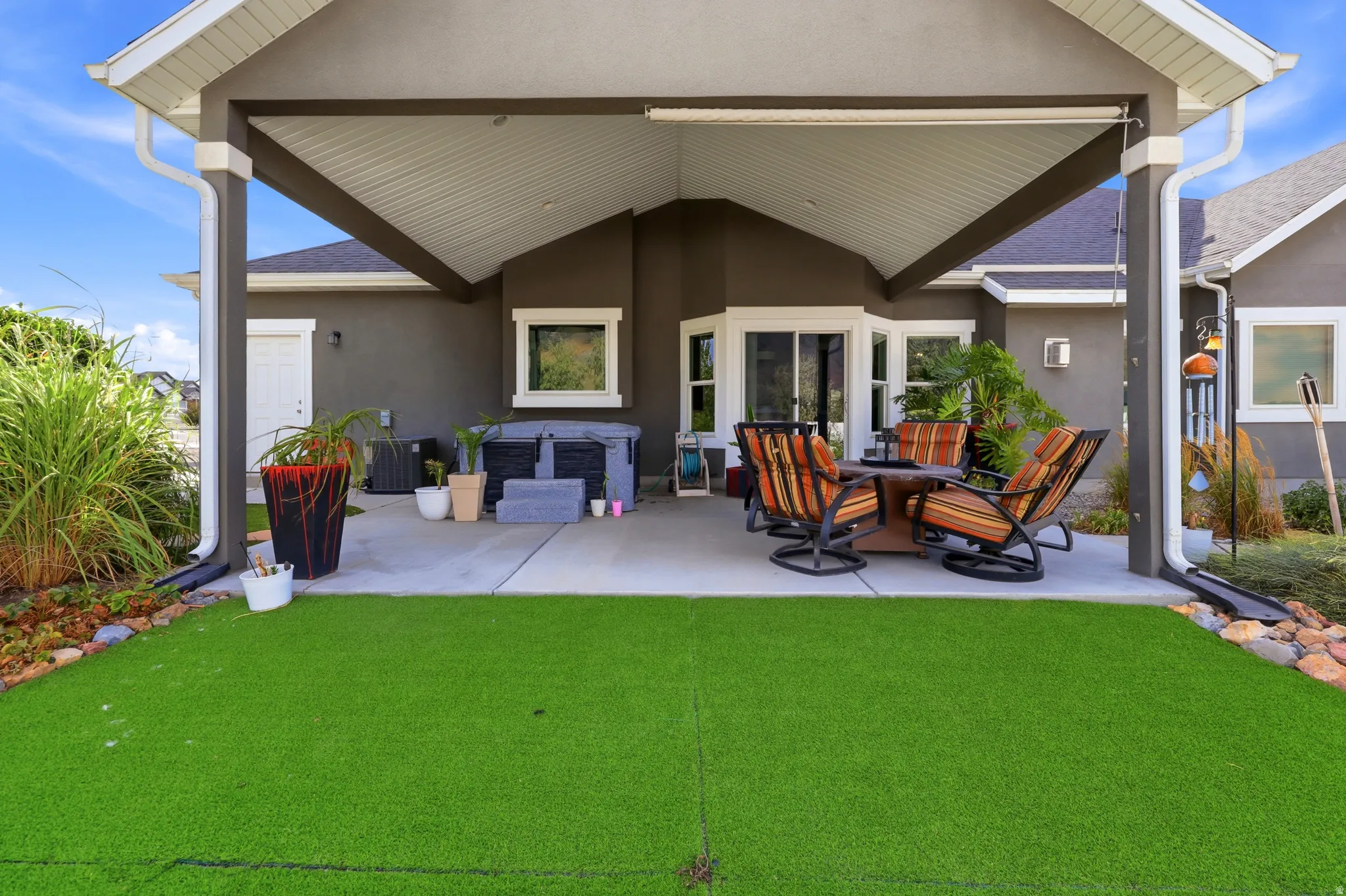 Expansive covered patio with a textured concrete surface and white support columns
