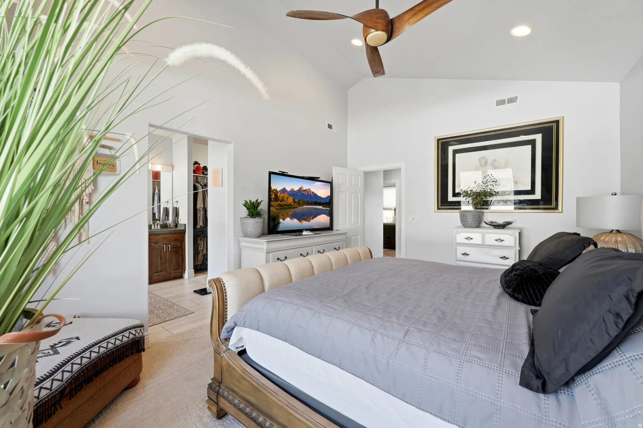 Vaulted ceiling with a wood-finish ceiling fan and recessed lighting