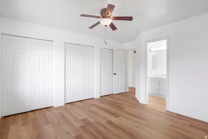 Bright interior space featuring wood-finish flooring and a ceiling fan with integrated lighting