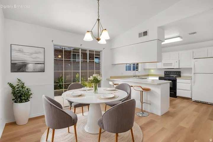 Open concept dining area featuring wood-finish flooring and a contemporary chandelier