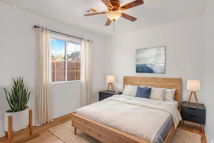 Bright bedroom with wood-finish flooring and a ceiling fan