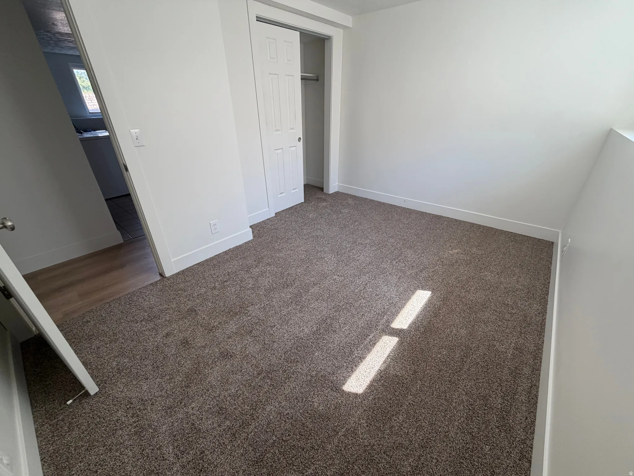 Room featuring neutral wall paint, brown carpet flooring, and white baseboards