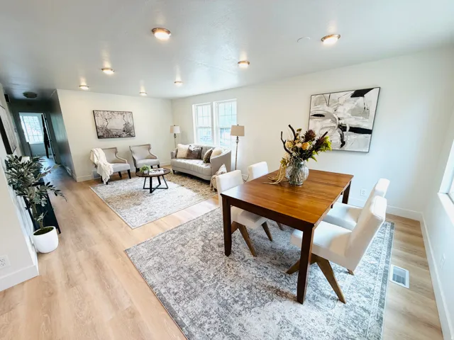 Open-concept living space featuring light wood-finish flooring, recessed lighting, white baseboards, and multiple windows providing natural light