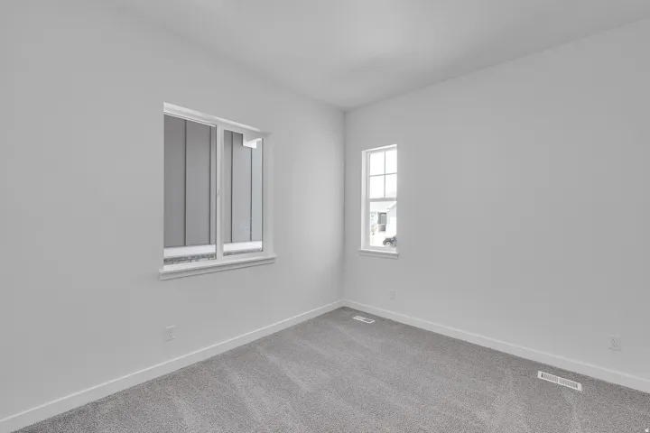 Neutral wall finishes with a light gray carpet