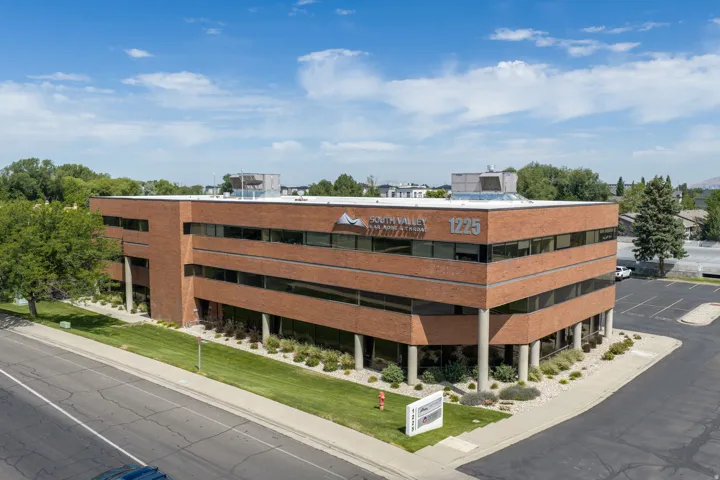 Three-story commercial building featuring brick exterior construction and extensive ribbon windows