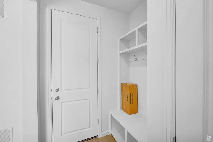 Mudroom featuring built-in white cabinetry, integrated bench seating, and upper storage cubbies