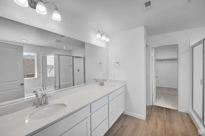 Double vanity with white cabinetry, integrated sinks, and a large mirror