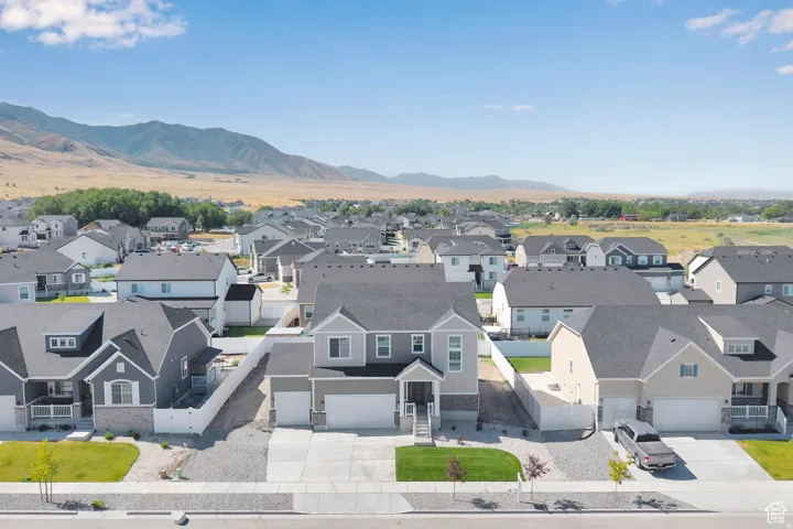 Two-story residence featuring a gray exterior with stone accents, a covered front porch, and a two-car garage