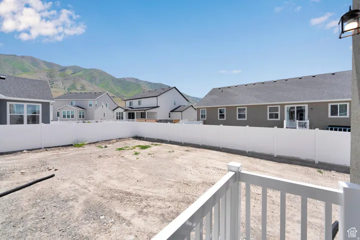 Expansive, undeveloped backyard space with a white vinyl privacy fence