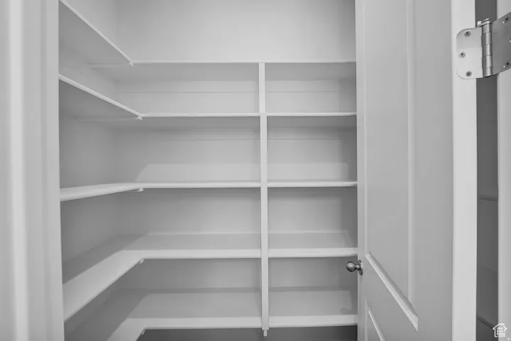 Spacious pantry featuring multiple tiers of white shelving