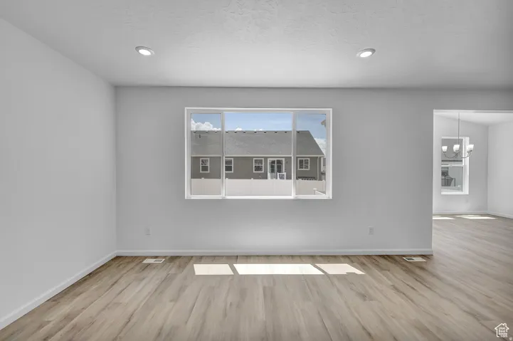 Spacious interior featuring a large picture window, recessed lighting, and wood-finish flooring
