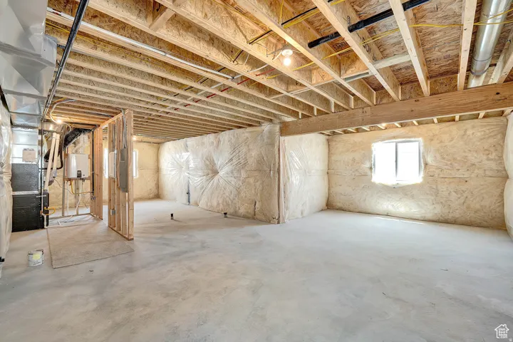 Unfinished basement with concrete flooring and exposed ceiling joists