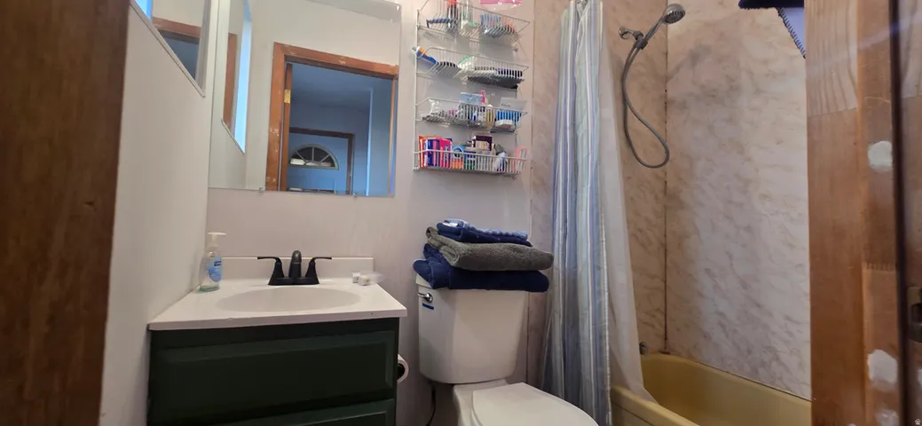 Bathroom featuring a vanity with dark green cabinetry, a white countertop, and a black faucet