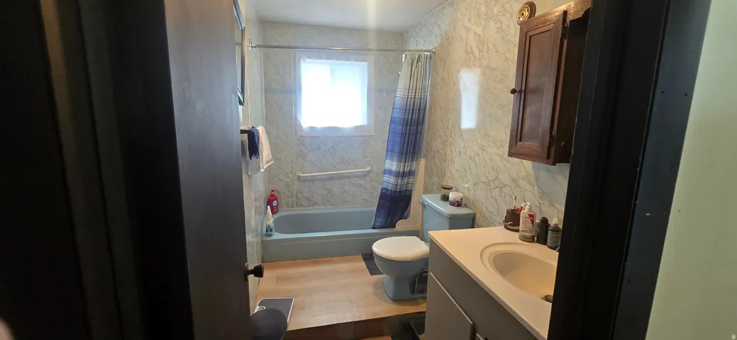 Bathroom featuring a light blue bathtub, light blue toilet, and a vanity with an integrated sink