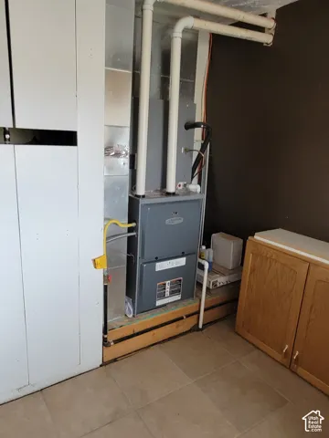 HVAC system with visible ductwork, gas line, and PVC piping on a raised wooden platform