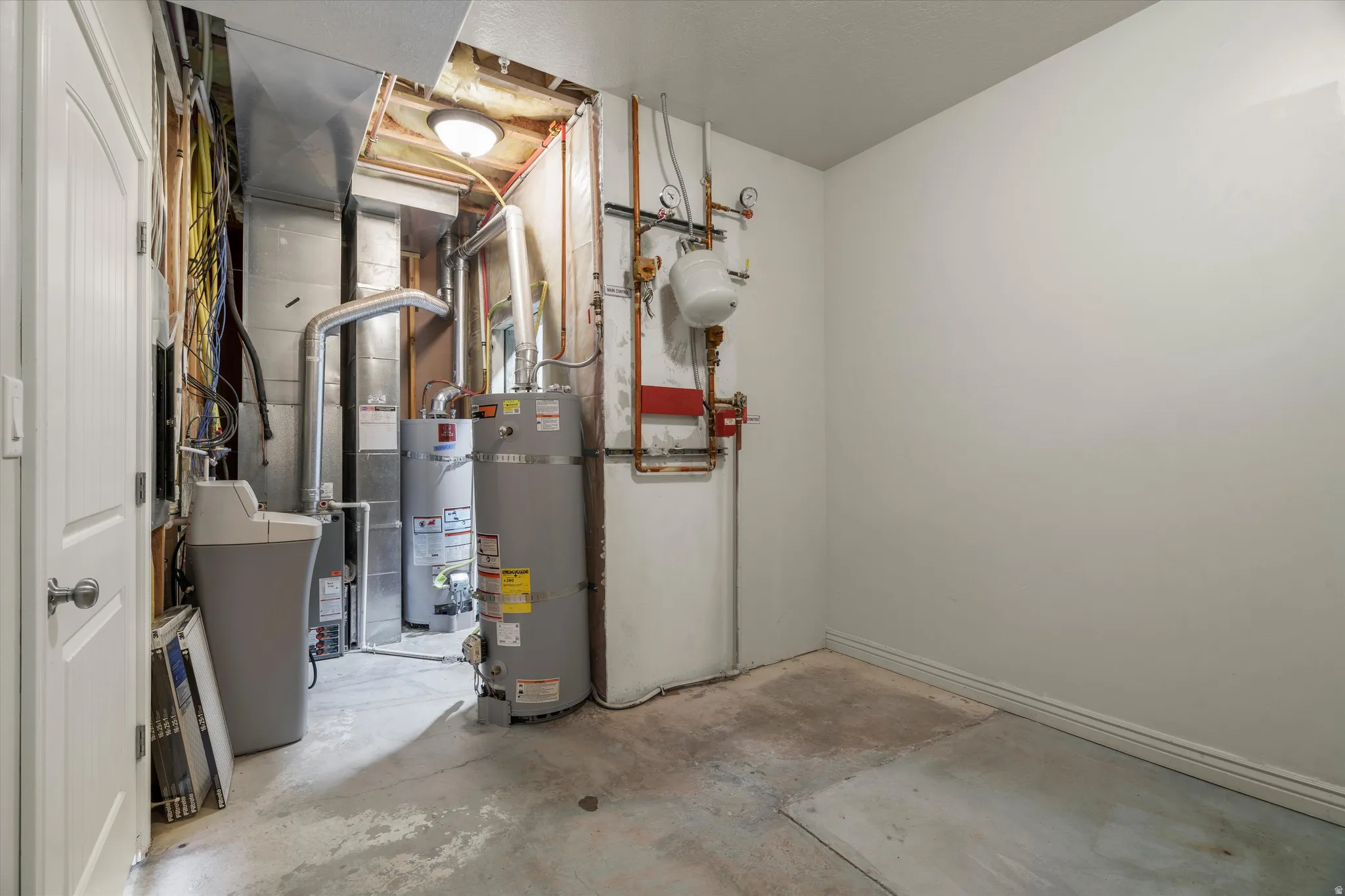 Utility area featuring a water heater, furnace, and water softener system