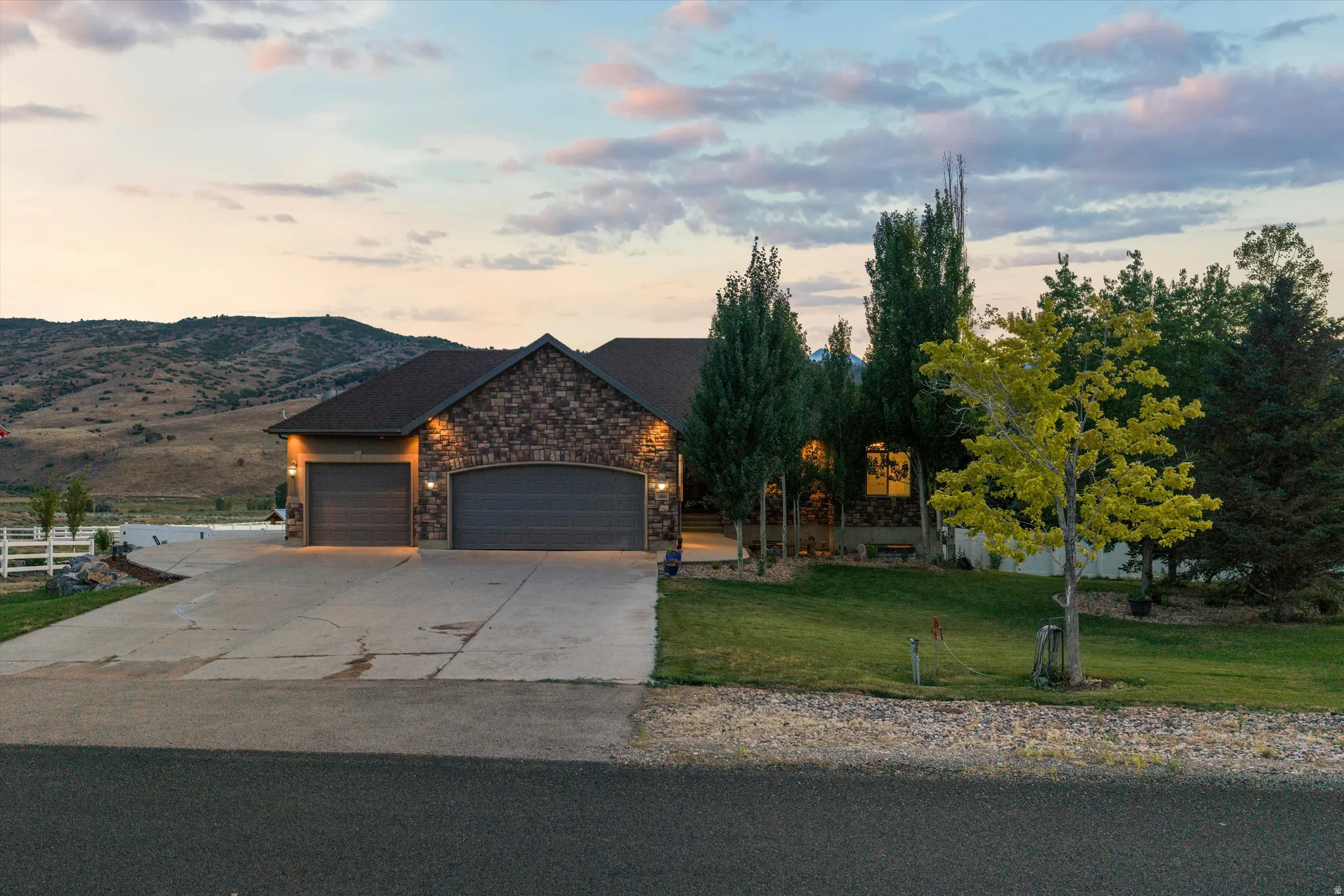 Stone facade residence with a dark roof and integrated two-car garage