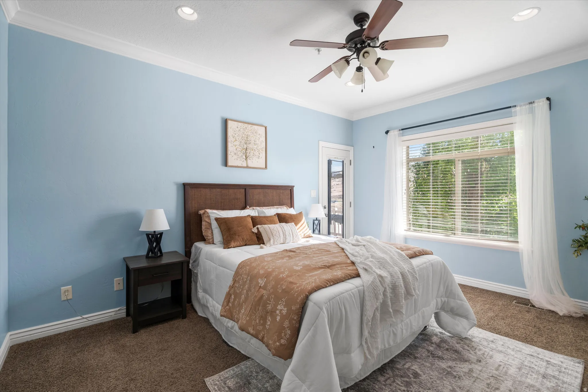 Carpet flooring and light blue walls featuring white crown molding and baseboards