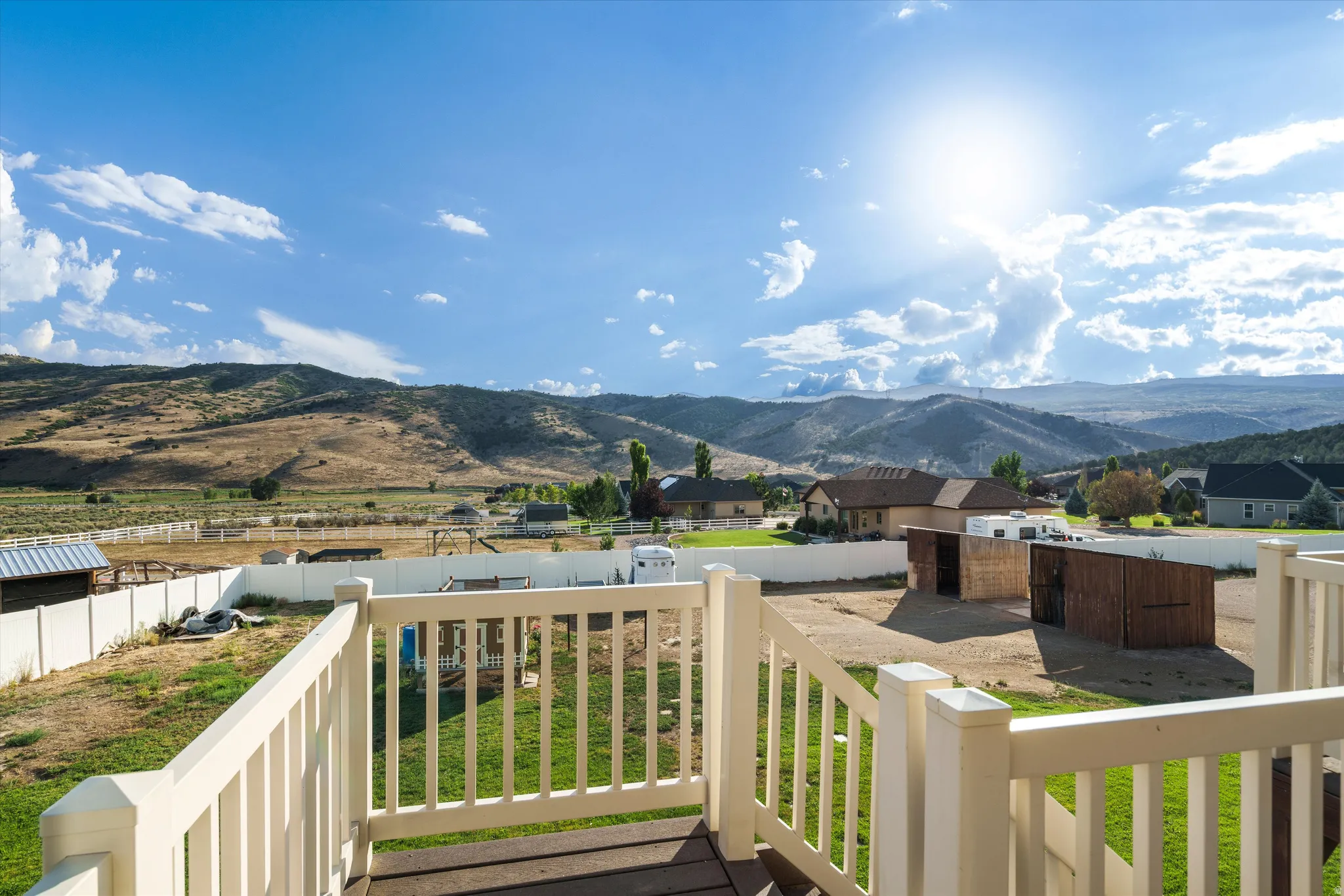 Expansive outdoor deck with a white railing system and dark wood-finish flooring