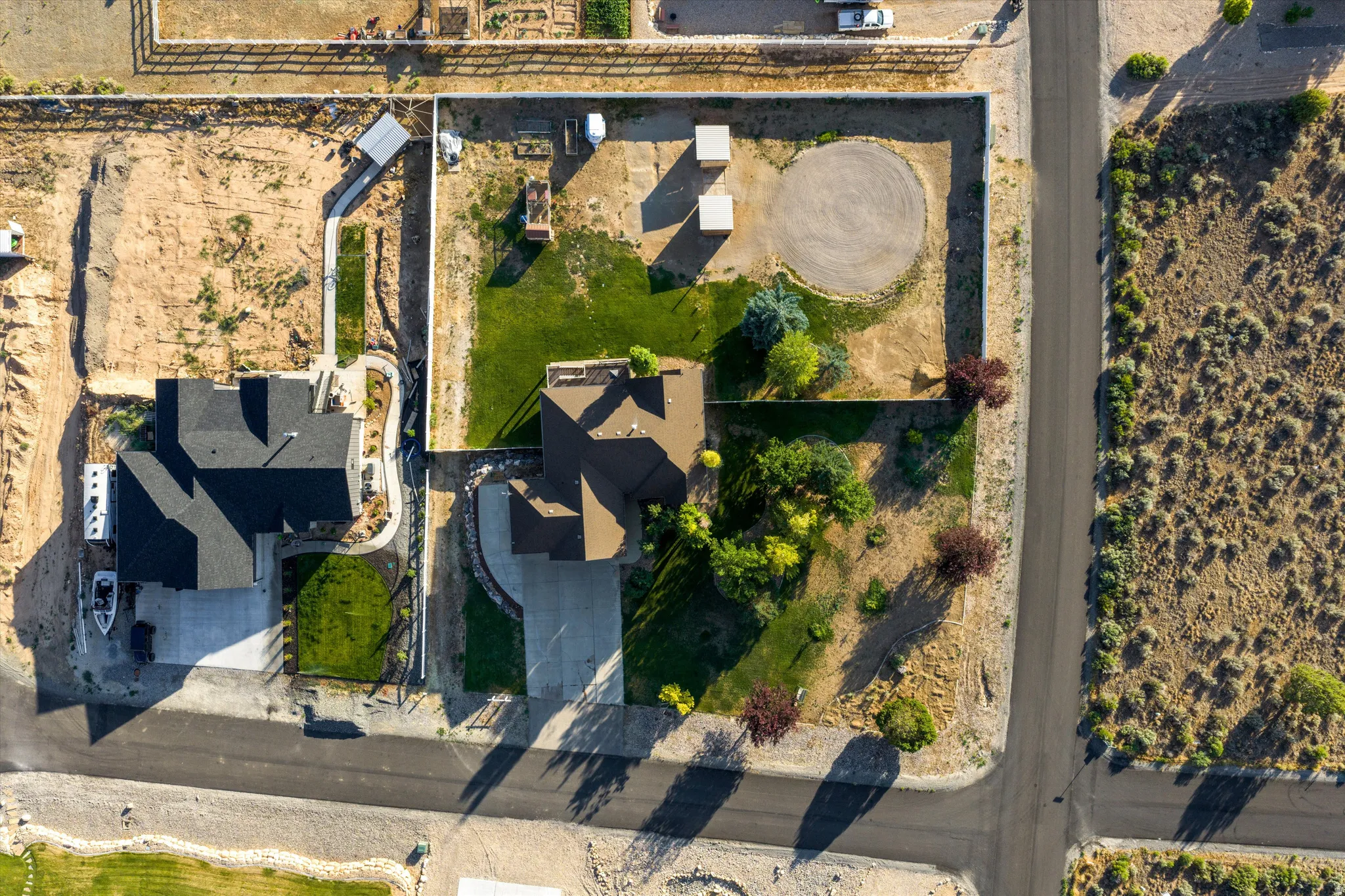 Aerial view showcasing two residential properties with distinct landscaping