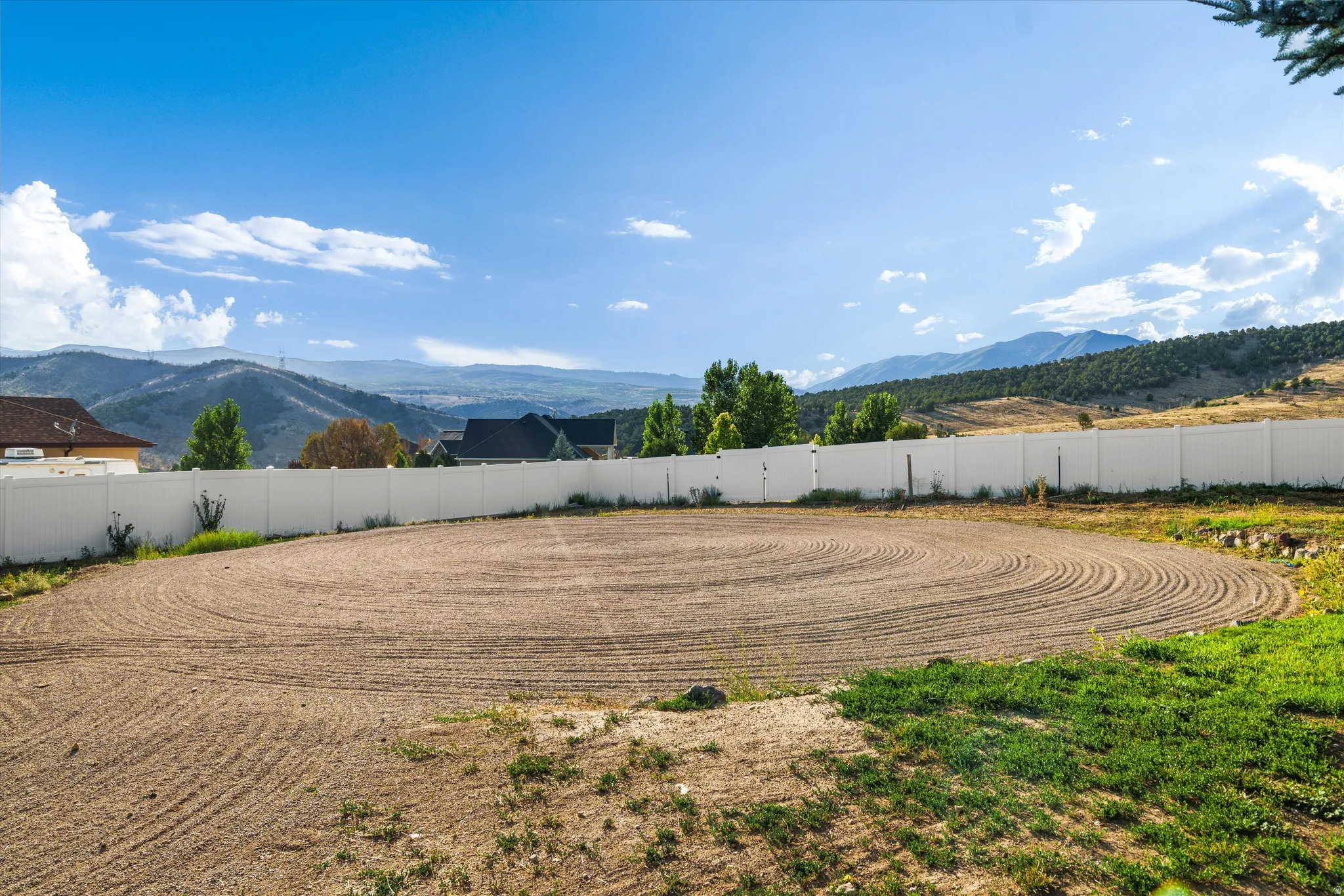 Expansive graded lot with a white privacy fence