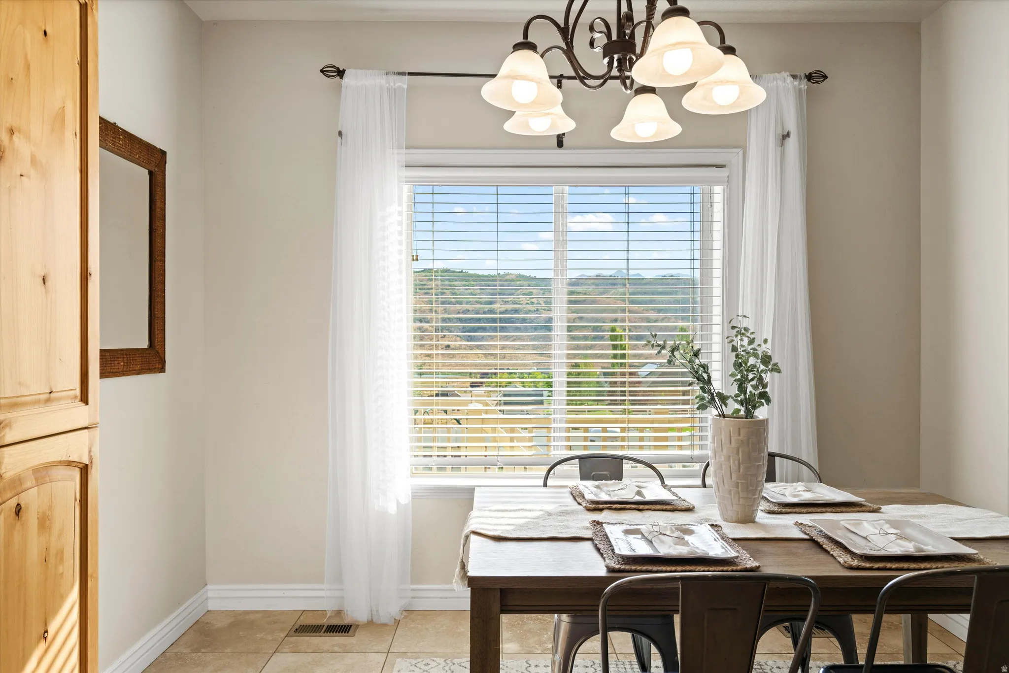 Dining area with a large window, providing natural light and showcasing a distant landscape