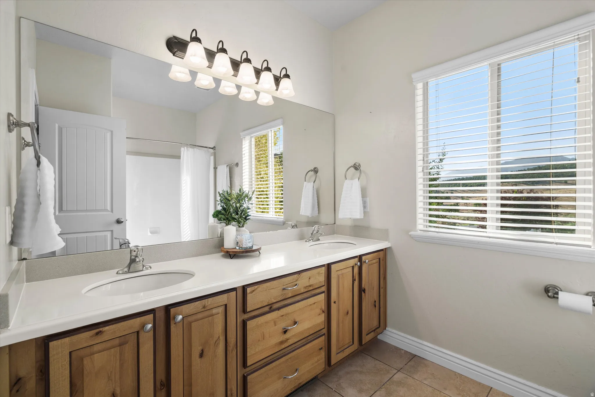 Dual vanity with light-tone countertops and natural wood cabinetry