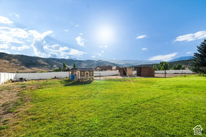 Expansive green lawn with a white privacy fence