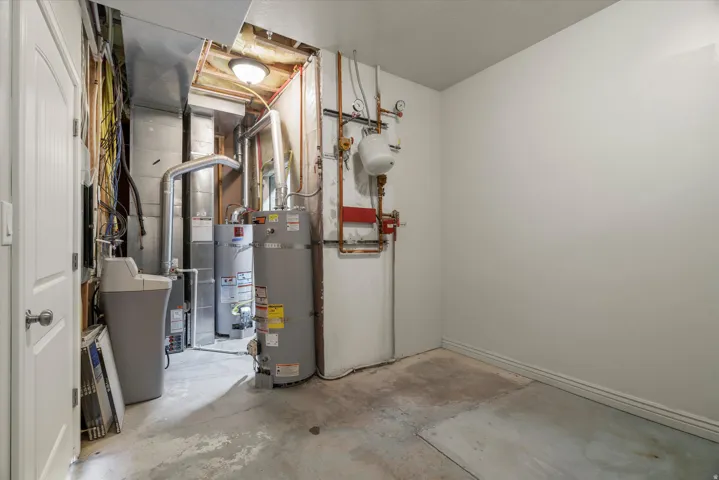 Utility area featuring a water heater, furnace, and water softener system