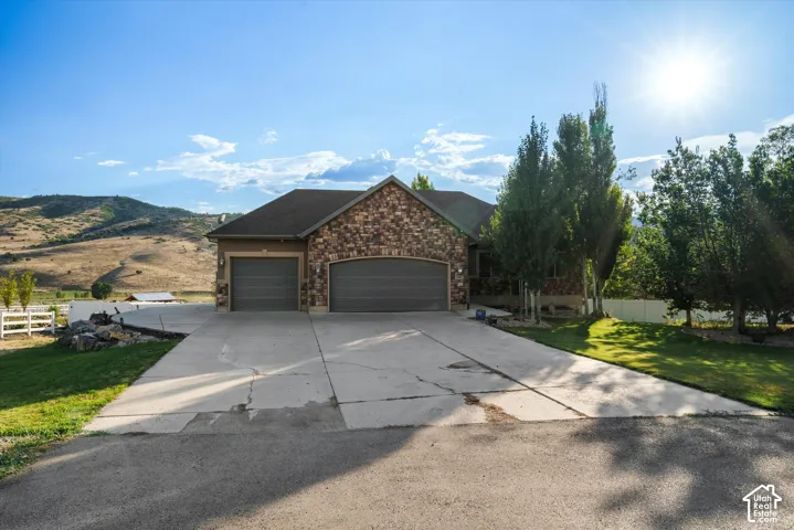 Stone and stucco exterior featuring a two-car garage with individual doors