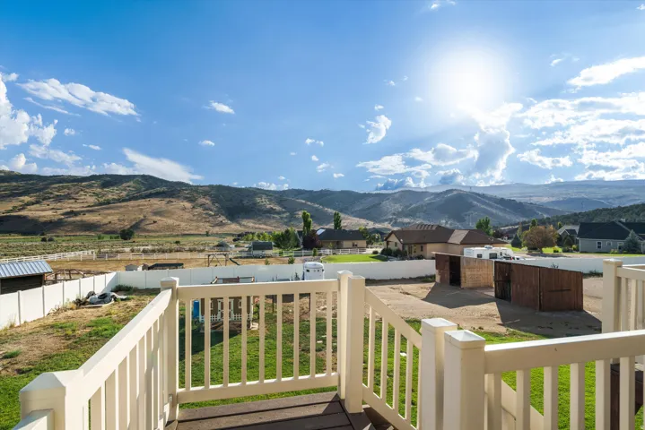 Expansive outdoor deck with a white railing system and dark wood-finish flooring