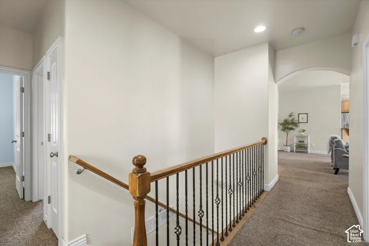 Stairway featuring wood handrails and wrought iron balusters