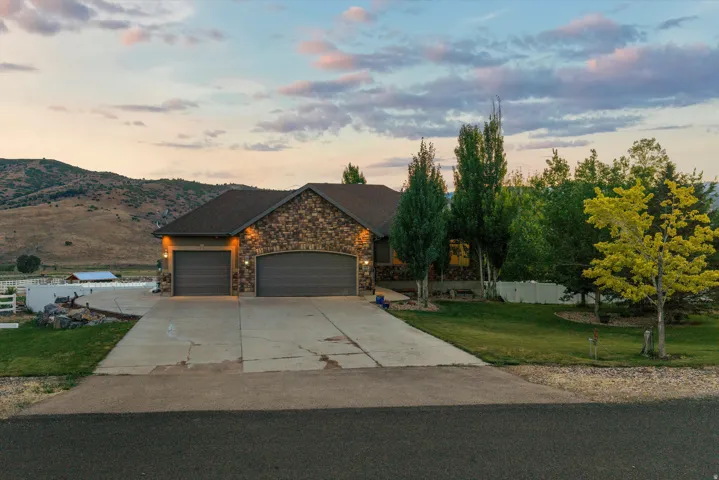 Stone veneer facade with a multi-car garage and a concrete driveway