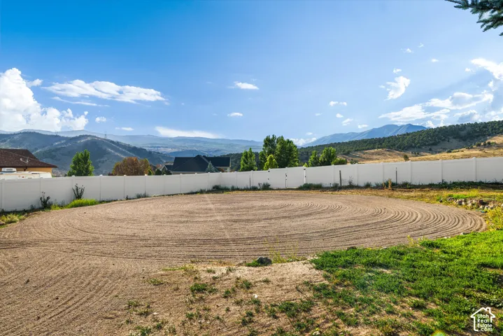 Expansive graded lot with a white privacy fence