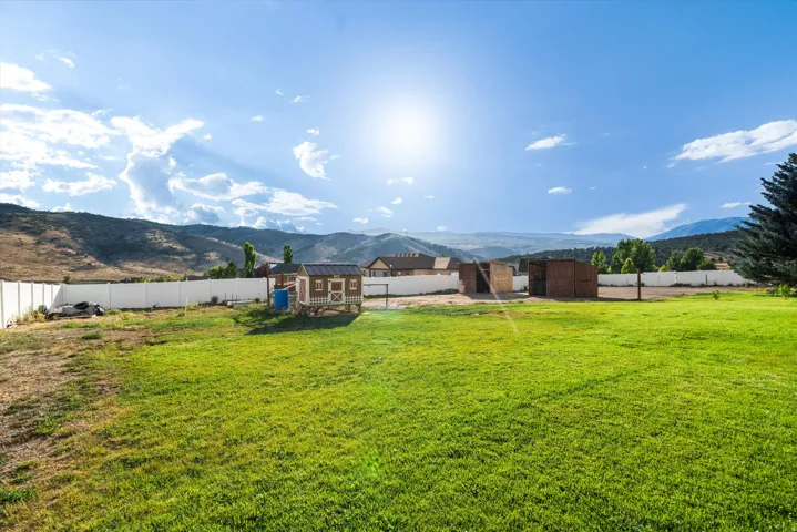 Expansive green lawn with a white privacy fence