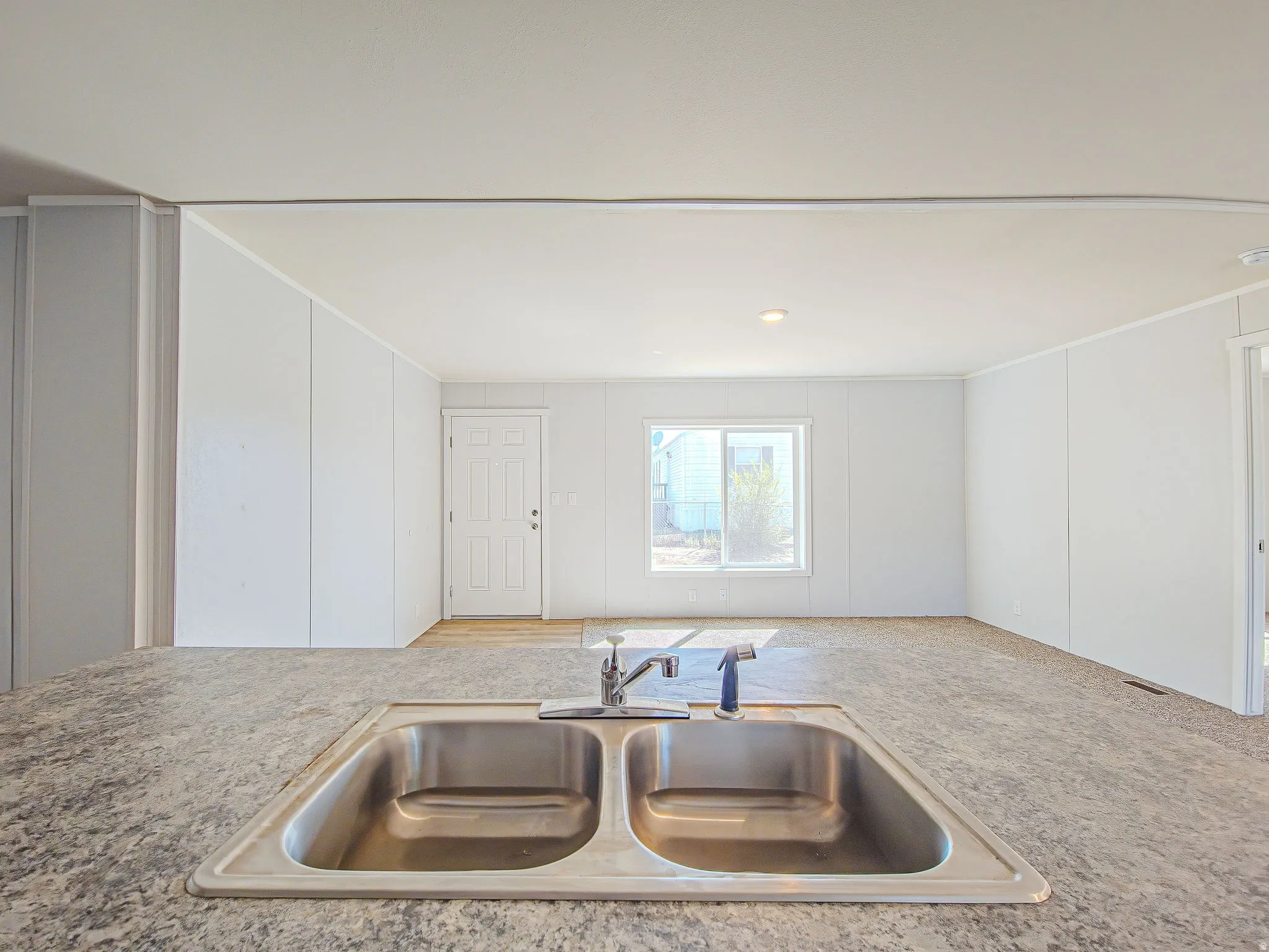 Stainless steel double basin sink with a single-handle faucet, set within a speckled countertop